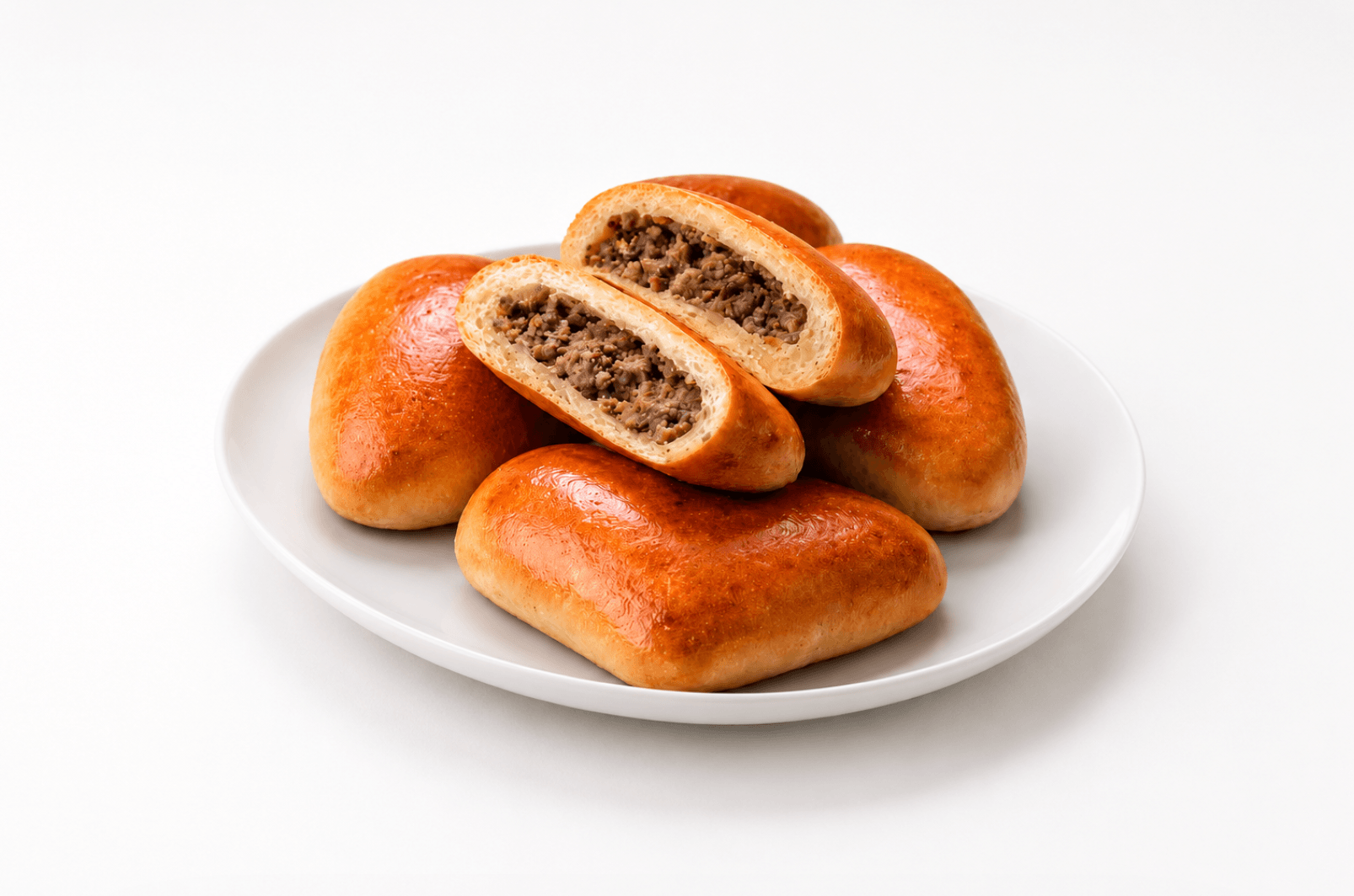 Golden baked pirozhki with different fillings on a wooden board