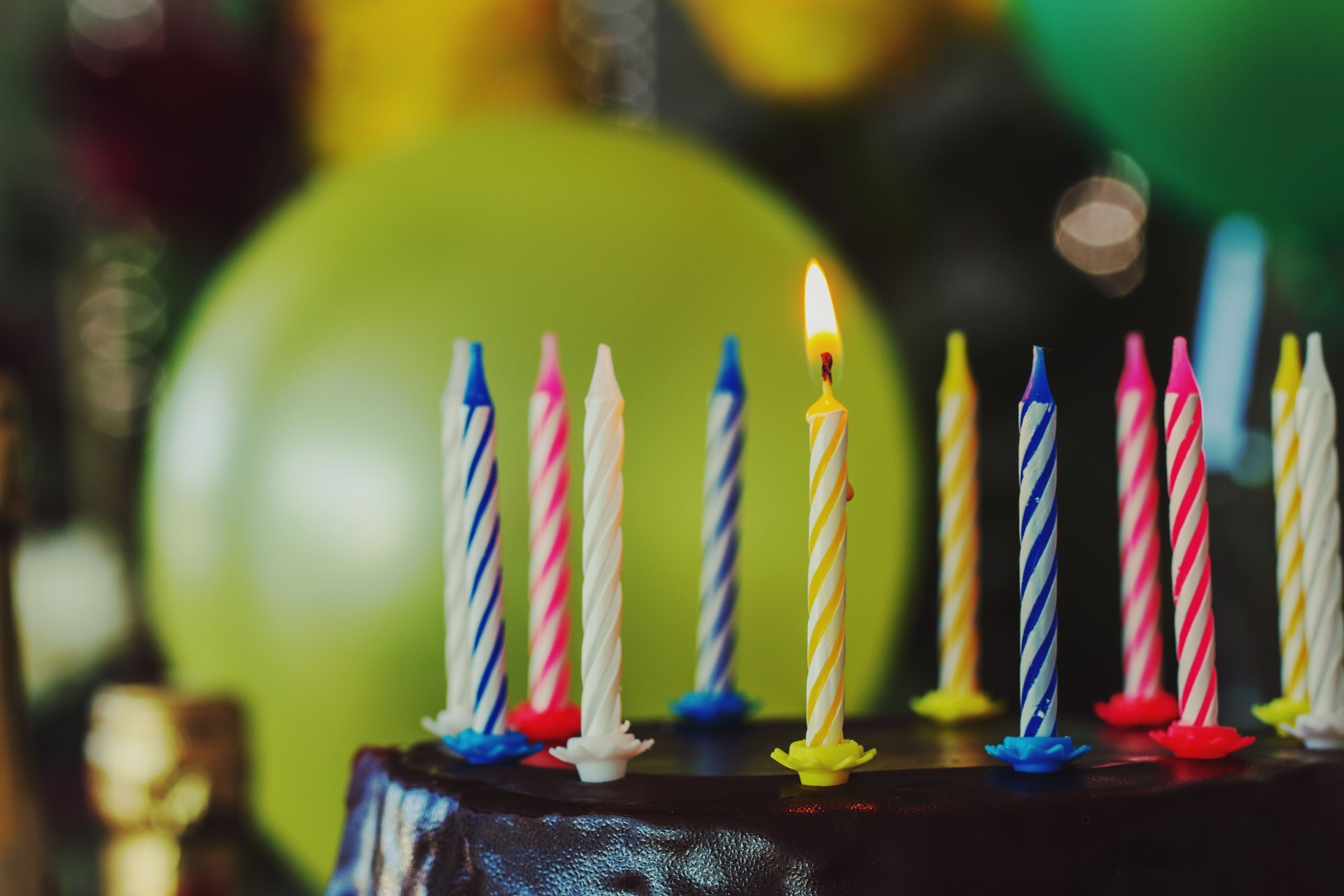 A birthday cake with candles ready to be carried to a table