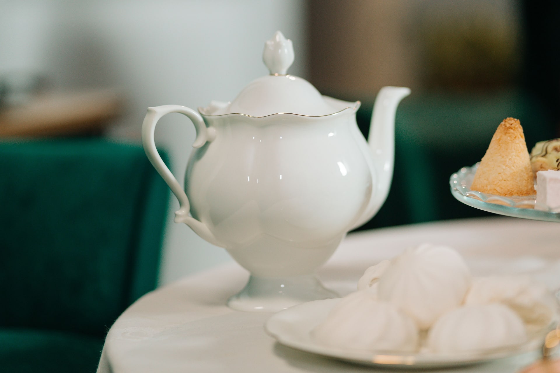 An afternoon tea table set with pastries, cakes and a teapot