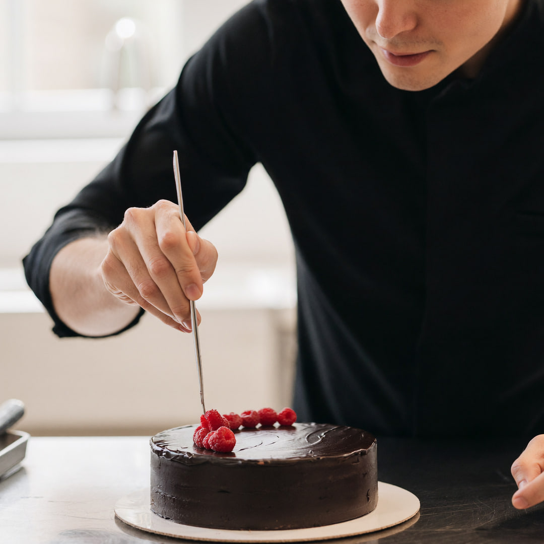 Mike Bakes, finishing a chocolate cake by hand in the Belgravia kitchen